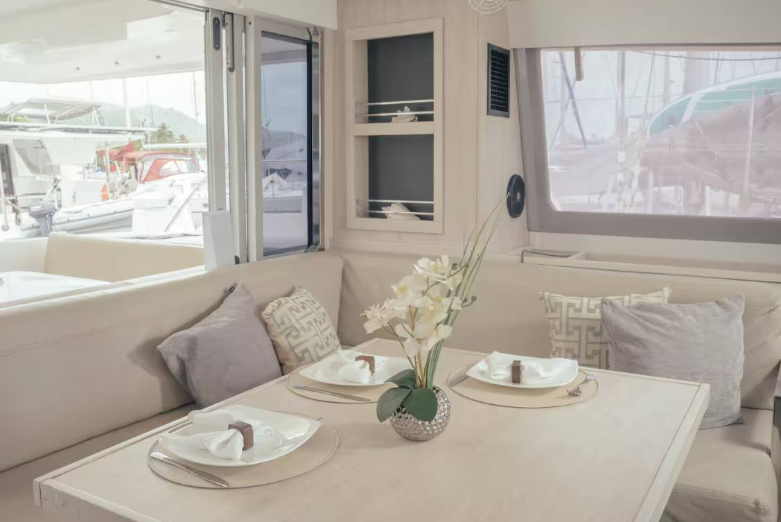 The interior saloon dining table set with plates and an orchid centerpiece